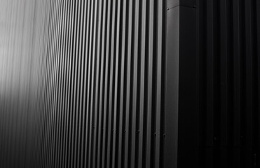 Wall Mural - Black corrugated iron sheet used as a facade of a warehouse or factory. Texture of a seamless corrugated zinc sheet metal aluminum facade. Architecture. Metal texture.