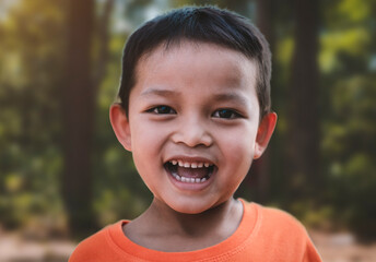 Portrait of happy smiling Asian child boy in nature, outdoors