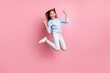 Full length body size view of pretty trendy cheerful girl jumping showing horn symbol isolated over pink pastel color background