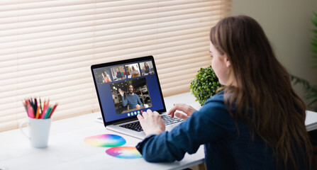 Poster - Caucasian businesswoman sitting at desk using laptop having video call with colleagues