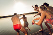 © Zoran Zeremski - Friends having fun enjoying a summer day swimming and jumping at the lake.