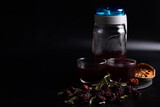 Fototapeta Kwiaty - Herbal juice mixed with okra, bael, stevia in a clear glass jug on a black background. Copy space