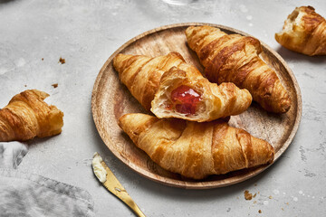 Wall Mural - Fresh croissants with butter and strawberry jam for breakfast.