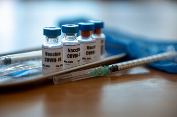 Selective focus on Vaccine bottle, Close up Coronavirus covid-19 vaccine bottle on table with syringe prepare for injection. Coronavirus infection prevention, diseases, medical care, science concept.