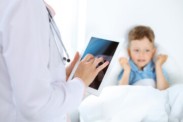 Happy smiling male kid-patient at usual medical inspection. Doctor and young boy in the clinic. Medicine concepts