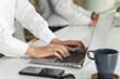 © amnaj - Close-up  of a young woman typing using a laptop at the meeting.