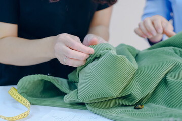 Women tailor hands working with fabric designs in a textile industry