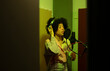 © Jose Carlos Cerdeno/ADDICTIVE STOCK - Black female singer performing song against microphone with pop filter while standing and closed eyes in sound studio