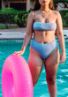 © Jose De Jesus Saldana/ADDICTIVE STOCK - Crop unrecognizable plump female tourist in swimwear with inflatable ring standing against swimming pool during summer vacation