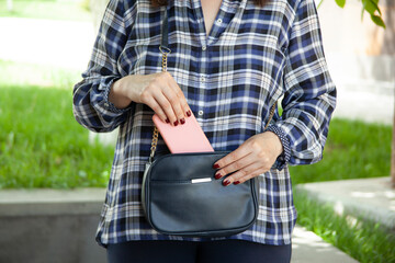 Wall Mural - woman hand phone in bag in street