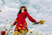 From Below Of Elegant Female In Hat Among Blooming Flowers In Countryside Field On Summer Day