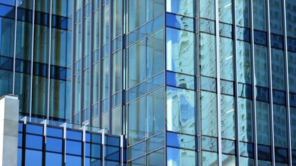 Glass facade of the buildings with a blue sky. Skyscrapers in the business city center.. Background of modern glass buildings. 