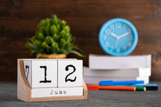 Wall Mural - June 12th. June 12 wooden cube calendar with blur objects on background.