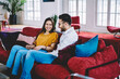 © BullRun - Joyful hipster guys dating and flirting while resting on cozy couch, funny couple in love talking about relationship and smiling enjoying home comfort and communication in modern apartment