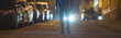 © realstock1 - The man stand outdoor on the background of a headlight. Evening night time