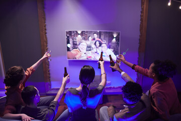 Wall Mural - Group of young people toasting to friends online while enjoying party at home