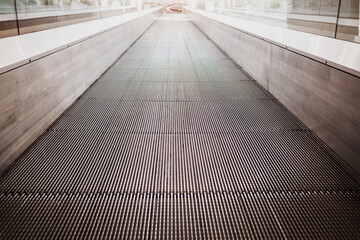  Flat escalator in a shopping mall without people, luminous unfocused background.