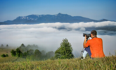 Wall Mural - photographer in nature. man and mountain landscape, Romania