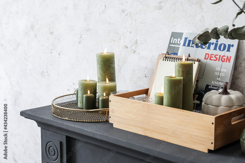 Beautiful burning candles on mantelpiece, closeup