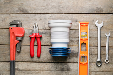 Set of plumber's items on wooden background