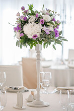 Centerpiece Made Of Green Leaves And Fresh Flowers Stands On The Dinner Table. Wedding Day. Fresh Flowers Decorations.