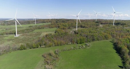 Wall Mural - Aerial panorama of white wind turbines on the green hills with trees, blue clear sky