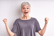 © Roman - Smiling happy young woman with short hair celebrating the win, cheering with raised arms, screaming, happily looking at camera, isolated on white background. win, celebration, holiday, luck concept