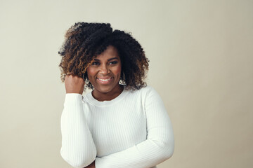 Wall Mural - Beautiful Smiling Woman Wearing a white sweater looking at camera