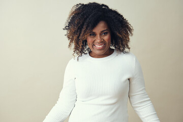 Wall Mural - Cheerful African American woman with frizzy hairstyle dancing against a white background