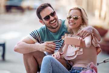 Wall Mural - Young couple taking selfie in the city