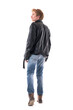 © sharplaninac - Back view of confident stylish young blond man in leather jacket walking turning away. Full body length isolated on white background