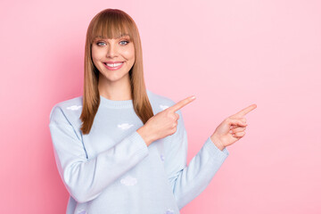 Wall Mural - Portrait of attractive cheerful girl demonstrating ad copy empte place space isolated over pink pastel color background