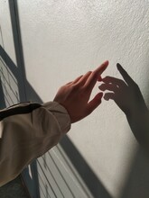 Cropped Image Of Hand Touching Wall