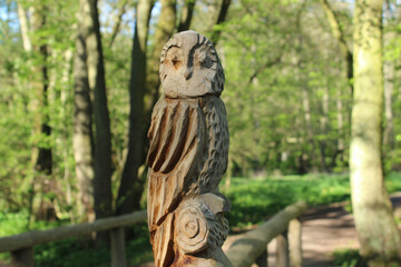 Closeup shot of a wooden owl figure in the green garden background