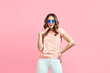 © GVS - Trendy young woman in blue sunglasses posing over pink background