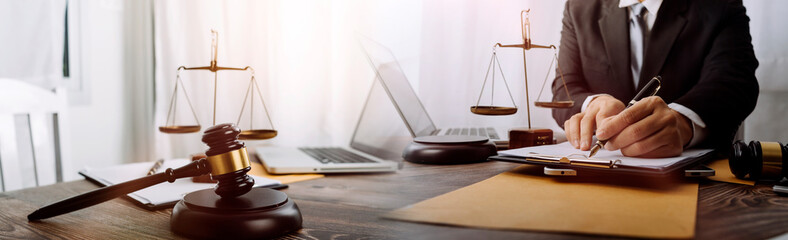 Business and lawyers discussing contract papers with brass scale on desk in office. Law, legal services, advice, justice and law concept picture with film grain effect