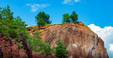 Wall Mural - visiting the extinct volcano we climb the reddish rocks covered with green vegetation