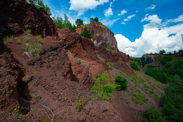 Wall Mural - visiting the extinct volcano we climb the reddish rocks covered with green vegetation