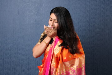 beautiful hindu girl  wearing traditional indian saree dress and ethnic jewelry holding flower.