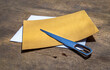 Envelope opener knife made of Stainless steel and two letter envelope on old wooden desk. Selective focus