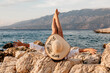 Rear View Of Young Woman Laying On Beach With Feet Up In The Air. Lifestyle, Enjoying Carefree, Sea.