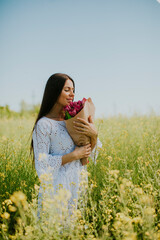 Wall Mural - Young woman in the rapeseed field