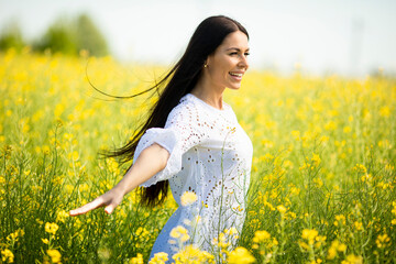 Wall Mural - Young woman in the rapeseed field