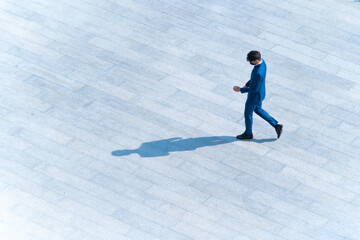 top aerial view businessman people walk on across pedestrian concrete with black silhouette shadow on ground, concept of social still life.