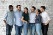 © fizkes - Happy diverse interns or newcomer employees celebrating getting hired, sharing success, hugging, talking, laughing. Smiling people discussing together teamwork. We are like multi racial family