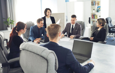 Wall Mural - Group of young successful businessmen lawyers communicating together in a conference room while working on a project