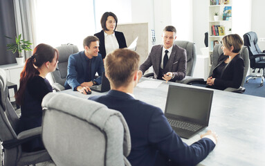 Wall Mural - Group of young successful businessmen lawyers communicating together in a conference room while working on a project