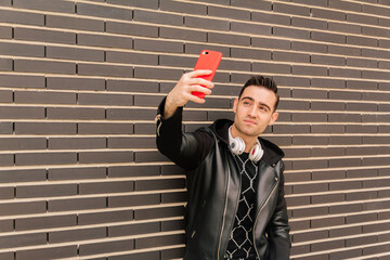 Young man taking a selfie or a photo for his social networks. Lifestyle and influenzer concept