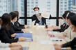 © pkrn - In a meeting room, a sales manager is discussing sales forecast with his team during covid-19.