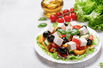 Wall Mural - Healthy Greek Vegetables Salad with cheese on white stone table background. Healthy food with fresh vegetables for dinner. Mediterranean cuisine. Close up, copy space